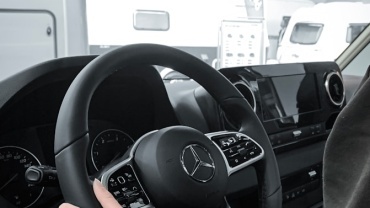 a person sitting in a car with a steering wheel