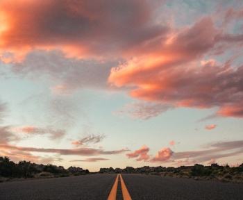 gray concrete road under cloudy sky during daytime