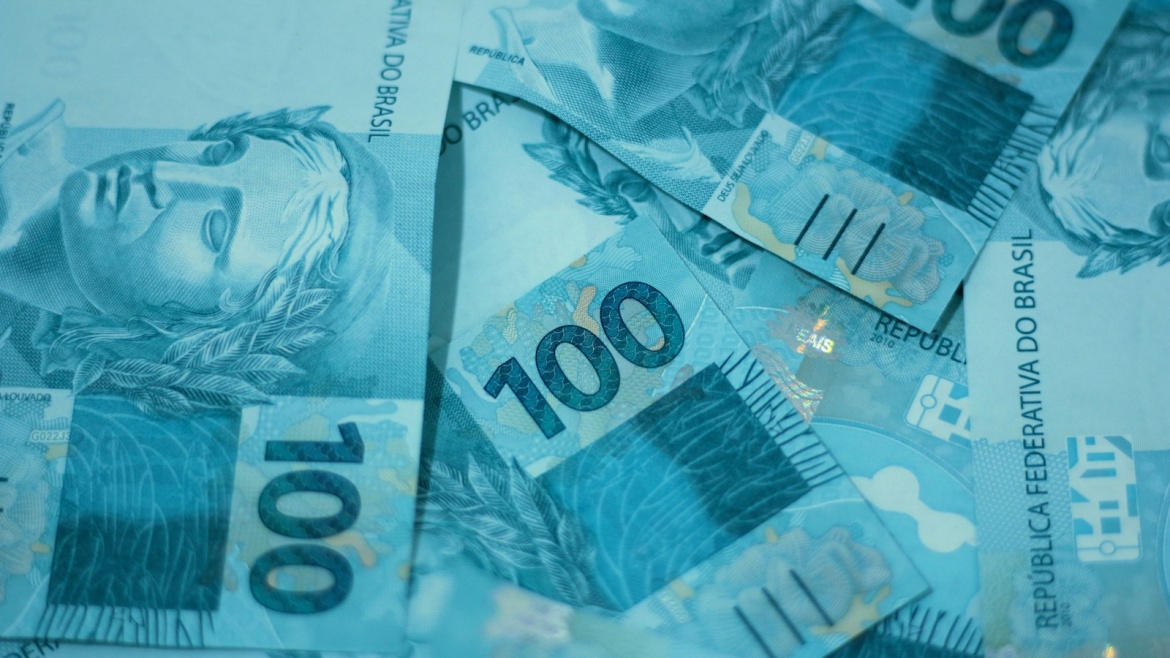 a pile of ten hundred dollar bills sitting on top of each other