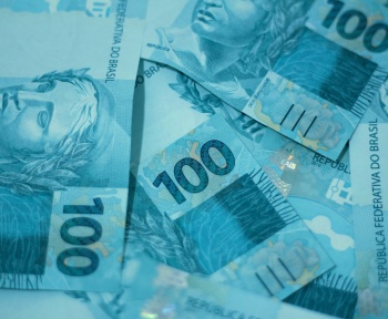 a pile of ten hundred dollar bills sitting on top of each other