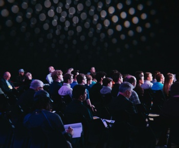 crowd of people sitting on chairs inside room