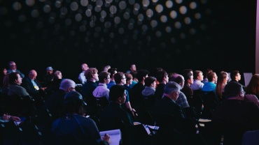 crowd of people sitting on chairs inside room