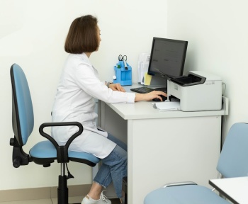 a woman sitting at a desk using a computer