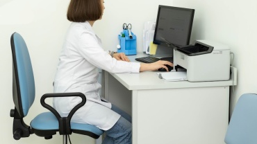 a woman sitting at a desk using a computer