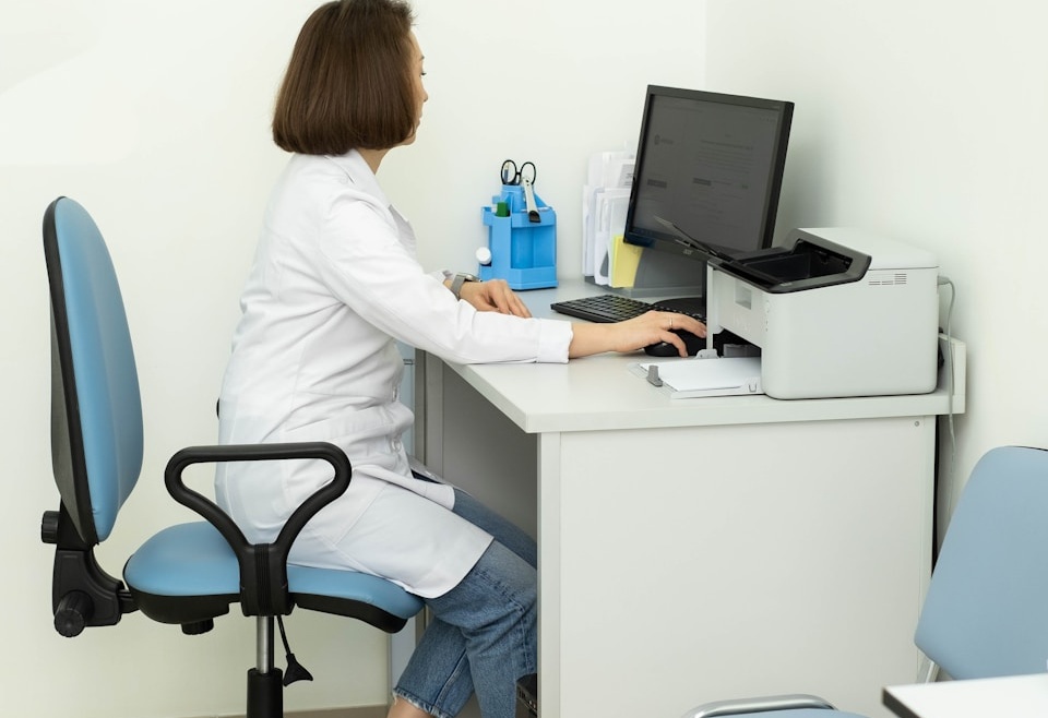a woman sitting at a desk using a computer