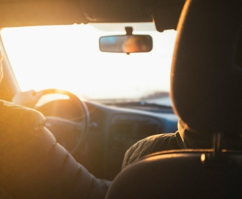 man driving car during golden hour