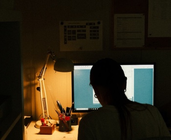 Person working on a computer in a dimly lit room.