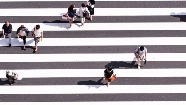 aerial view photography of group of people walking on gray and white pedestrian lane