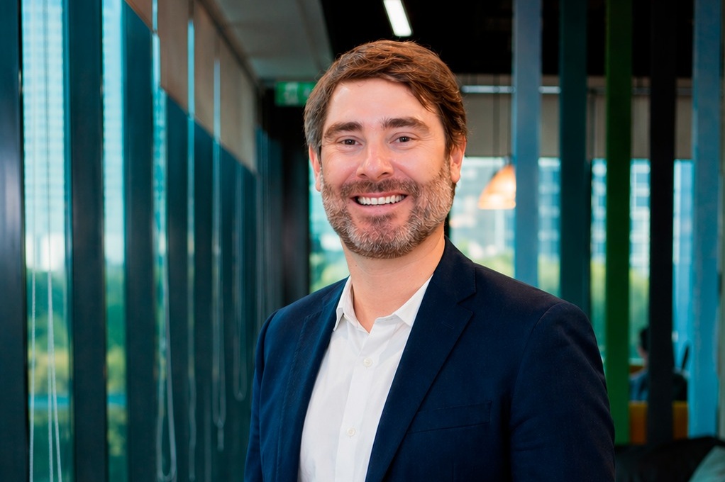 Matheus Fontanelli, diretor do Canal Cooperativas da AXA no Brasil, sorrindo em ambiente corporativo.